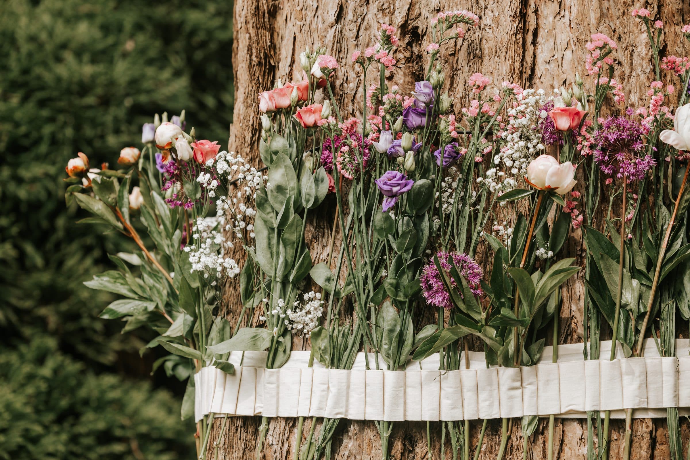 Boomstam met een band vol verse bloemen
