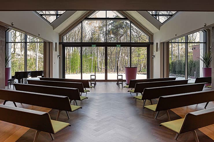 Aula van Crematorium Laren met glazen wand naar het bos