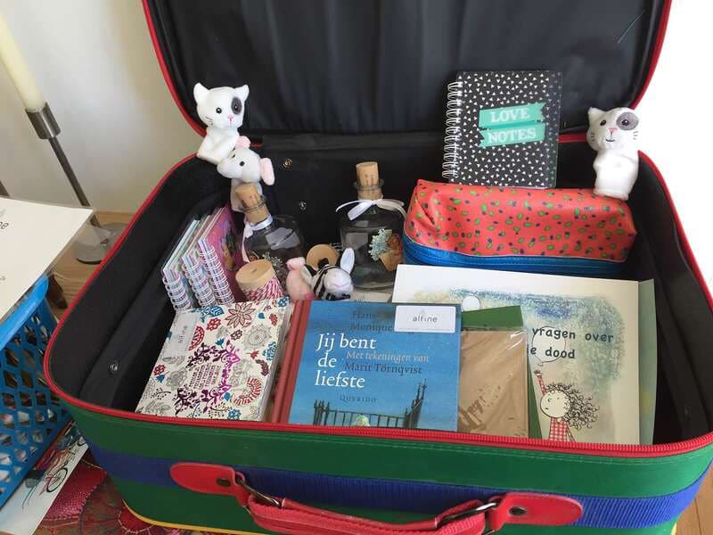 De kinderkoffer van Alfine met boeken, knuffels en tranenflesjes