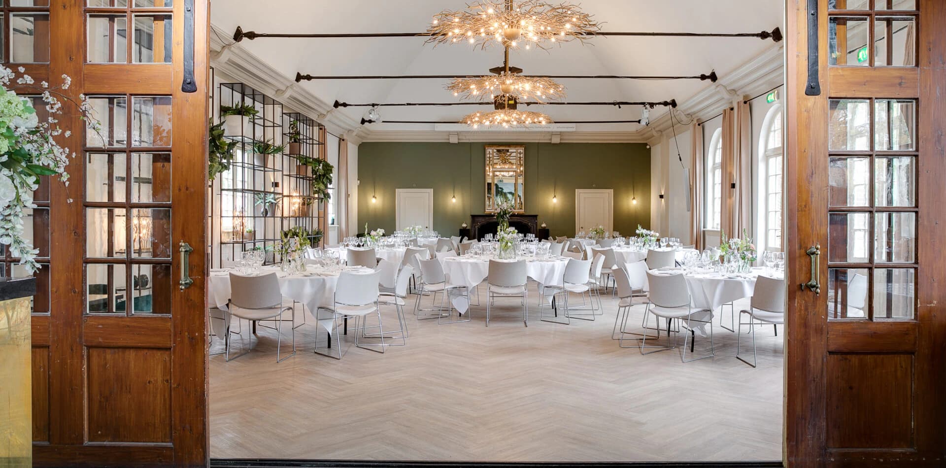 Lichte zaal met kroonluchters in het Koetshuis van Kasteel Amerongen