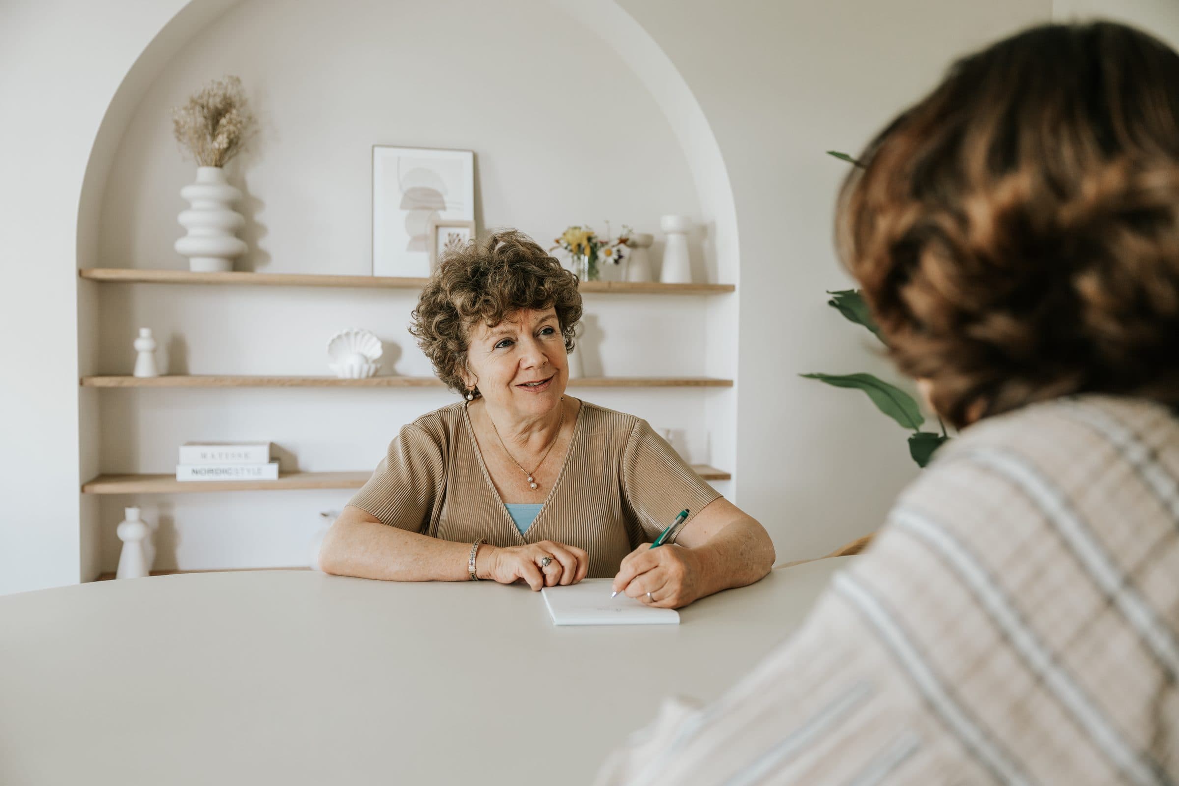 Moniek maakt aantekeningen tijdens een gesprek